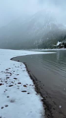 Lake Klöntal shoreline in the winter, snow covered frozen ground Switzerland