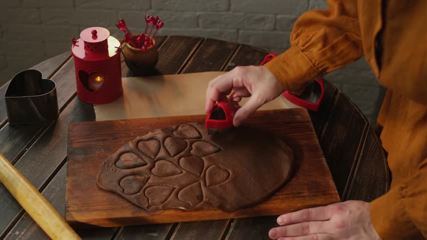 Preparing cookies for St Valentines day. Woman making heart shaped cookies
