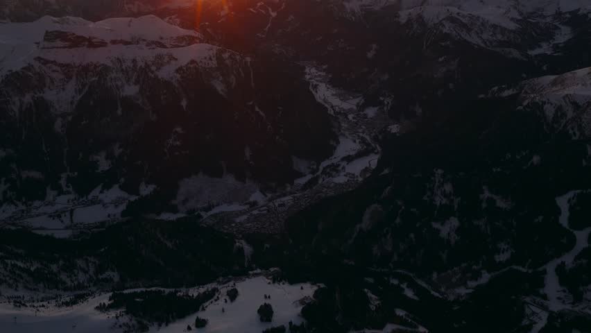 A breathtaking aerial view of the sunrise over the snowy mountains of Passo Pordoi, Italy.