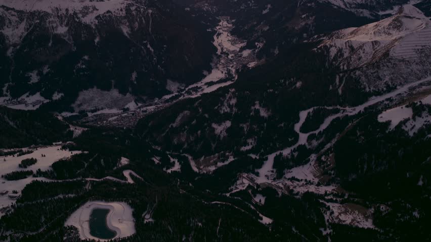 A breathtaking aerial view of the sunset over the snow-capped mountains of Passo Pordoi, Italy.