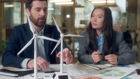 Windmill design agriculture discussion Caucasian man explains model Korean woman takes notes writing notebook green innovation rural technology sustainable farming solution clean energy eco teamwork - Powered by Shutterstock - Get 15% off with code: PIKWIZARD15