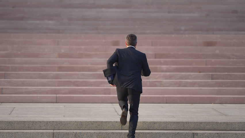 Business man run toward success. Businessman taking a strategic step on stairs. Business man walking up stairs with clear step progress. Businessman climbing stairs with each step forward.