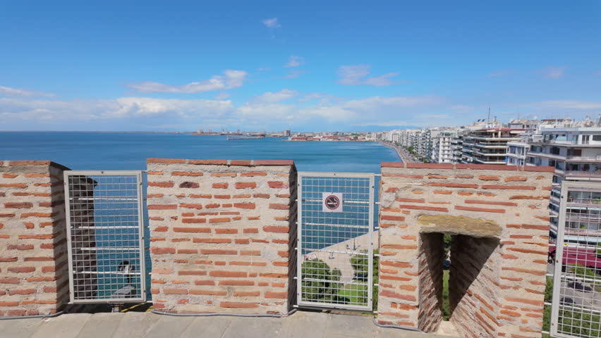 Stunning aerial view of a Greek coastal city with blue sea modern buildings and a clear sky on a sunny day.