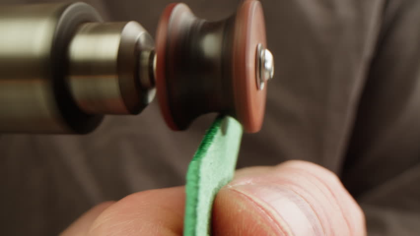 Man tailor repairing belt, artificial leather close-up. Craftsman making accessories made of genuine animal leather at workplace table. Professional atelier.
