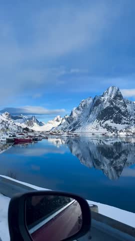 Winter Landscape of Fishing Village with Snow Covered Mountains and Mirror Reflection in Greenland Waters