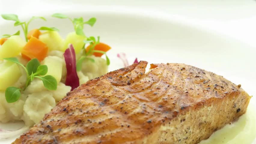 Delicious grilled salmon fillet served with roasted potatoes and fresh vegetable medley, showcasing healthy and gourmet cuisine.