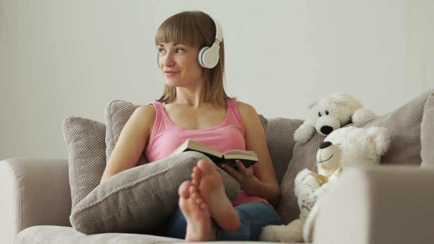 Woman reading book and listening music
