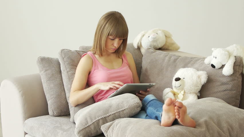 Woman sitting on sofa with tablet pc

