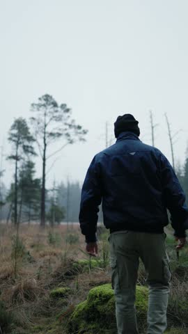 A solitary man standing on a moss-covered rock in a quiet forest, enjoying the calm atmosphere of nature. Cinematic outdoor scene symbolizing mindfulness, freedom, exploration, and connection with the natural environment.