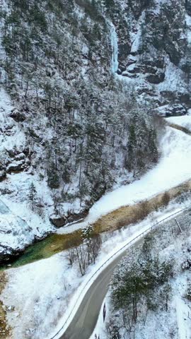Raccolana Valley and the Repepeit waterfall in the snow in winter. Vertical shot.