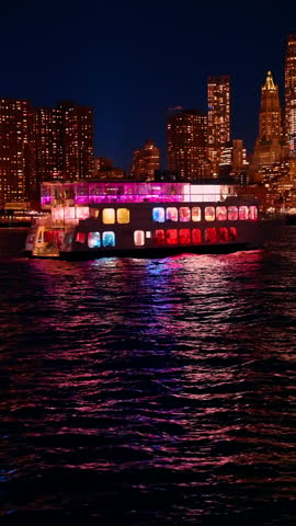 Night ferry with Manhattan city lights. Ferry boat passing Manhattan skyline with bright city lights at night.