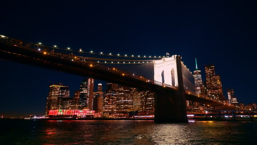 Lower Manhattan waterfront at night. Night waterfront view of Lower Manhattan with illuminated skyscrapers and harbor.
