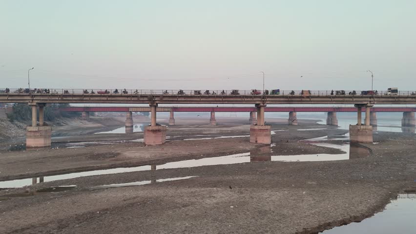 British era Railway Bridge over the river Ravi. The beautiful winter sunset behind the train. Location: Shahdara, Pakistan.