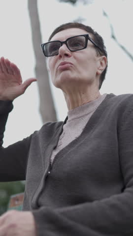 Woman discussing outdoors on park bench in winter clothing