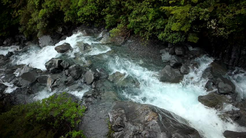 Fast River Rapids Over Dark Boulders