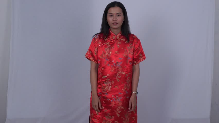 Asian woman in red Cheongsam smiling and dancing happily