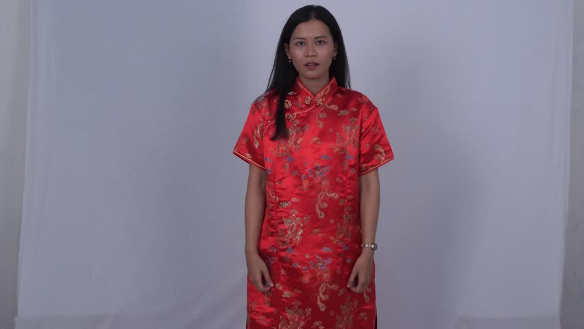 Asian woman in red cheongsam smiled and raised both hands