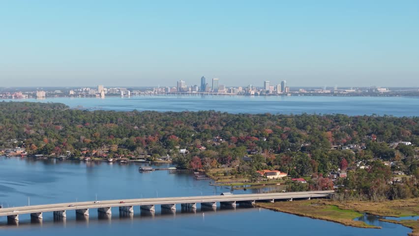 Moving shot of the Jacksonville (FL) skyline in the distance with a clear sky.
