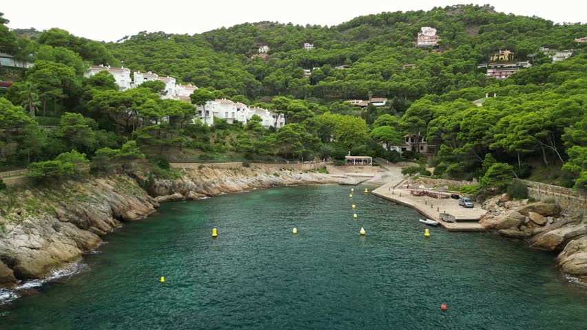 Aerial video of holiday destination in Costa Brava northern Spain in late summer showing beautiful rocky coast at Cala Aiguafreda