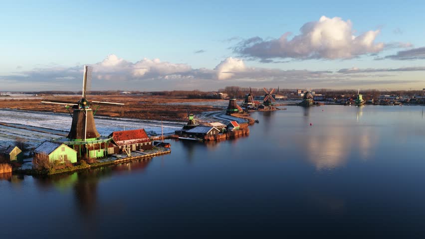Aerial winter view of the Zaanstreek windmills at Zaanse Schans, showing historic polder mills, snow landscape, and Dutch cultural heritage.