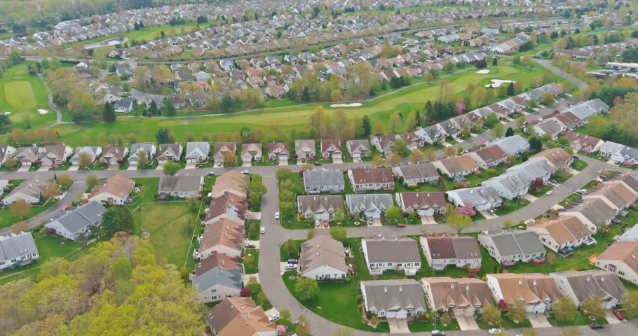 Expansive view East Brunswick New Jersey US arranged houses in suburban area with lush green parks course nearby.