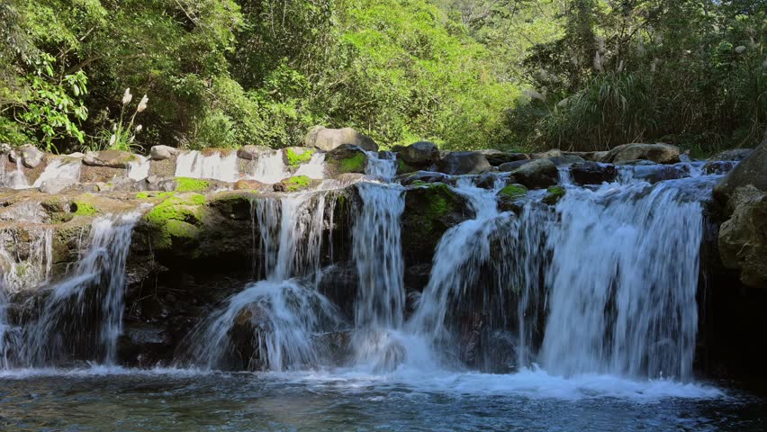Multiple waterfalls falling over a bare rock into a rapid flowing mountain stream.Sanxia, ​​New Taipei City.