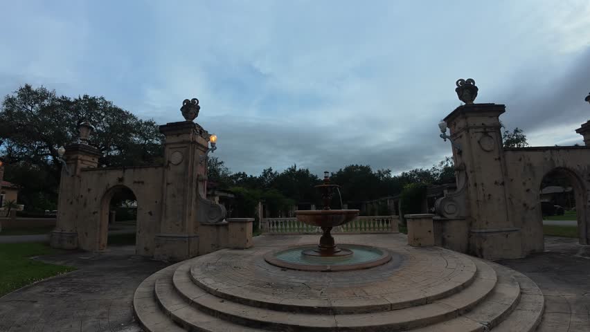 A detailed close-up shot focusing on water flowing from or over part of a historic fountain within ruins.

