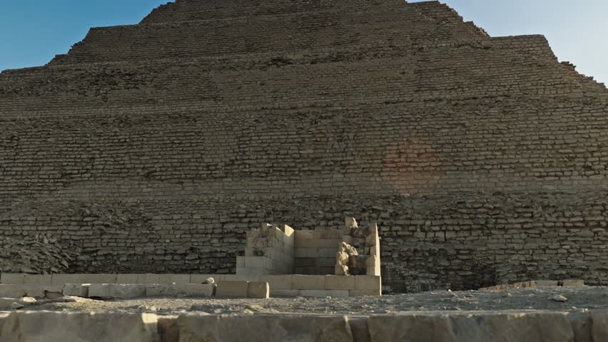 View of the Step Pyramid of Djoser at sunset, without any people in the frame. As the first pyramid ever built in Egypt, this six-tiered structure represents a monumental leap in architectural history