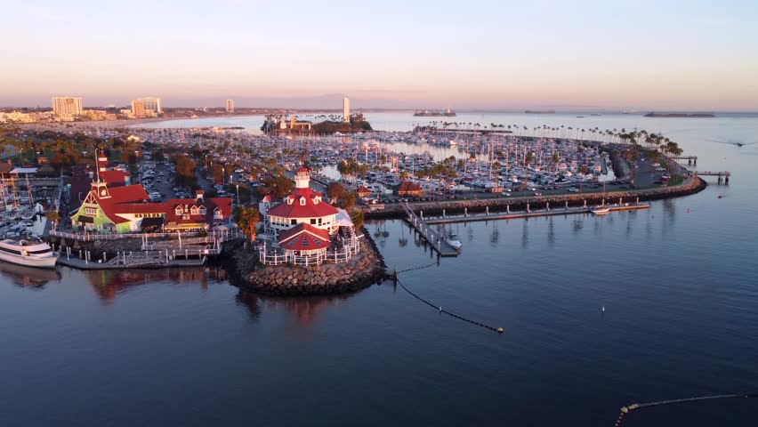 Aerial view of Shoreline Village in Long Beach, California showing the harbor marina, waterfront walkways, docked boats, and calm waters of Queensway Bay.