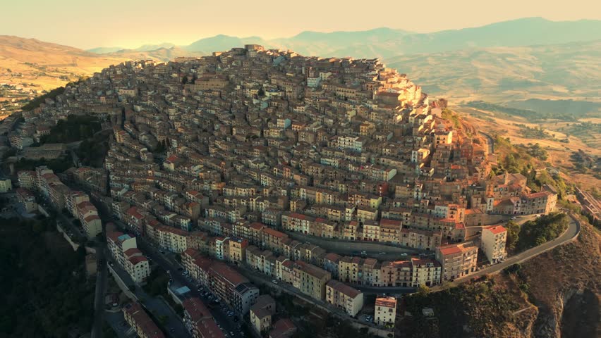 Aerial drone footage of Gangi village in Sicily, revealing a dense hilltop town surrounded by mountain landscapes.