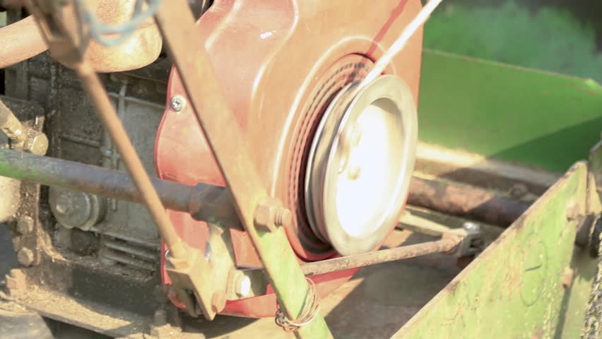 A worker operates a lawn cutter to trim overgrown grass in a park near India Gate, Delhi. The machine glides smoothly, maintaining the lush green landscape for visitors to enjoy.
