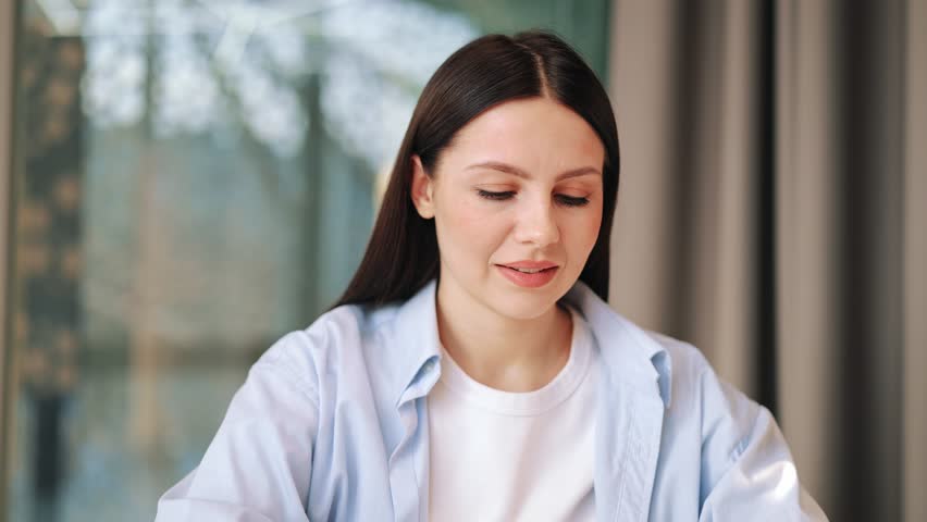 Woman smiles, closes eyes, stretching arms behind head. Contentment peace fill expression. Enjoying well deserved break, embracing calm moment after productive work. Satisfaction radiates from person.