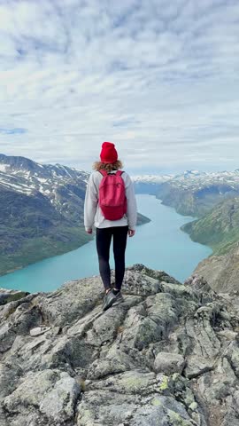 Vertical video of female hiker enjoying the scenic view of gjende lake from Besseggen ridge
