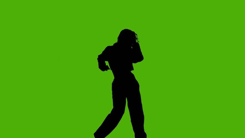 Silhouette of a dancer performing moves on a green screen background
