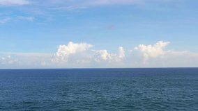 Aerial view of calm ocean water with fluffy clouds on the horizon. Perfect concept for travel, relaxation, tourism, promo, and nature backgrounds. High quality, scenic footage. - Powered by Shutterstock - Get 15% off with code: PIKWIZARD15