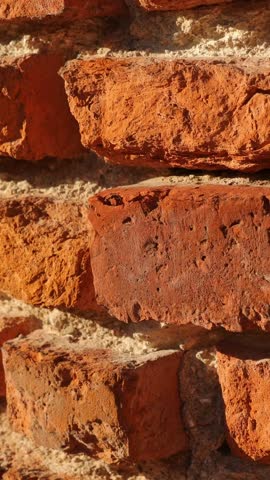 Sunlit aged brick wall, rich textures. Vertical video.