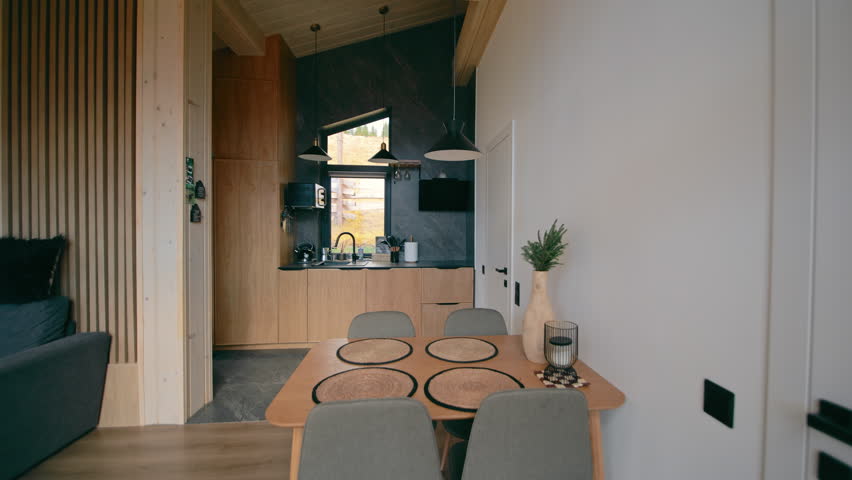 Modern kitchen and dining room interior with wooden furniture set, cozy home design with mountain view window and gray luxury chairs