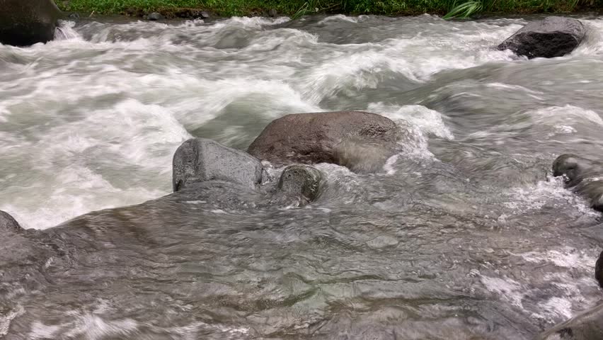 This video shows that the current is quite strong and the riverbed is uneven due to the many rocks. The water surface appears to foam white where it hits the rocks.