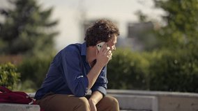 Enjoying the outdoors, a young man on a phone call gets greeted by a friend. They sit down, ready for a casual conversation and a moment of friendship. - Powered by Shutterstock - Get 15% off with code: PIKWIZARD15