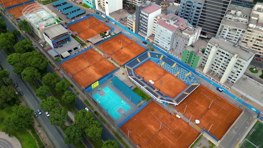 Busy sports fields next to a main avenue captured from a drone.	