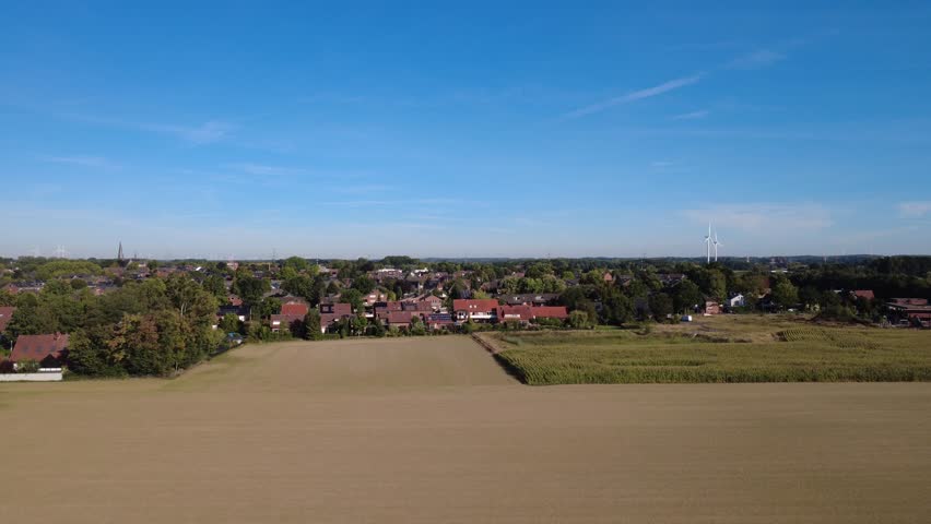 Aerial view of rural landscape with fields and forest under blue sky