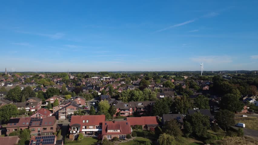 Aerial view of rural landscape with fields and forest under blue sky