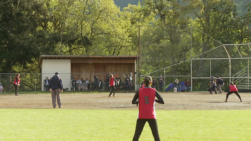 batter hits to first base in girls softball game
