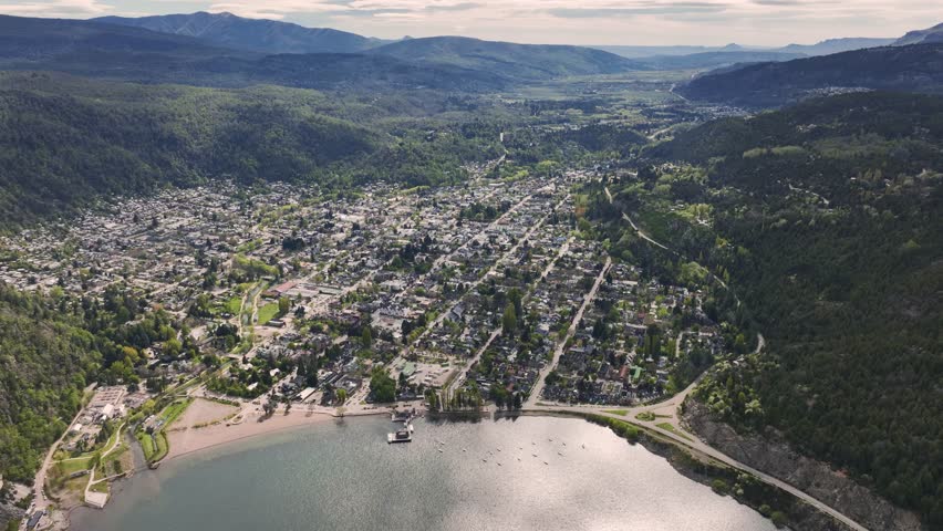 Aerial view of San Martín de los Andes city nestled in a valley between forested mountains on the shores of Lake Lacar in Patagonia, Argentina