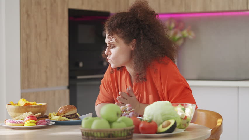 Young woman choosing french fries instead of vegetables, diet failure slip