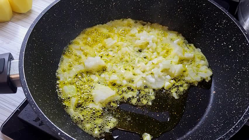Cooking onions and garlic in oil for a flavorful dish in the kitchen