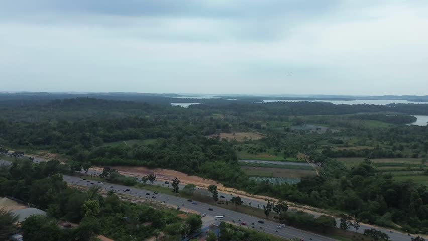 The view from above shows vast green forests, busy highways, and peaceful scenery in the distance.