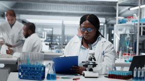 Female scientist using optical microscope to study microorganisms in laboratory, innovating. African american woman contributing to scientific community through detailed biological research, camera B - Powered by Shutterstock - Get 15% off with code: PIKWIZARD15