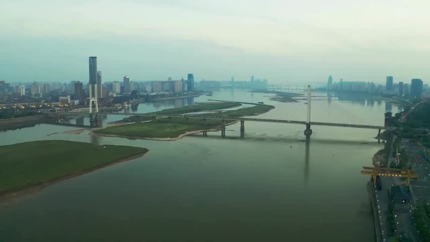 Cityscape of Nanjing, China with the Yangtze River and bridges, showcasing modern skyscrapers, flowing water, and an urban riverside panorama.