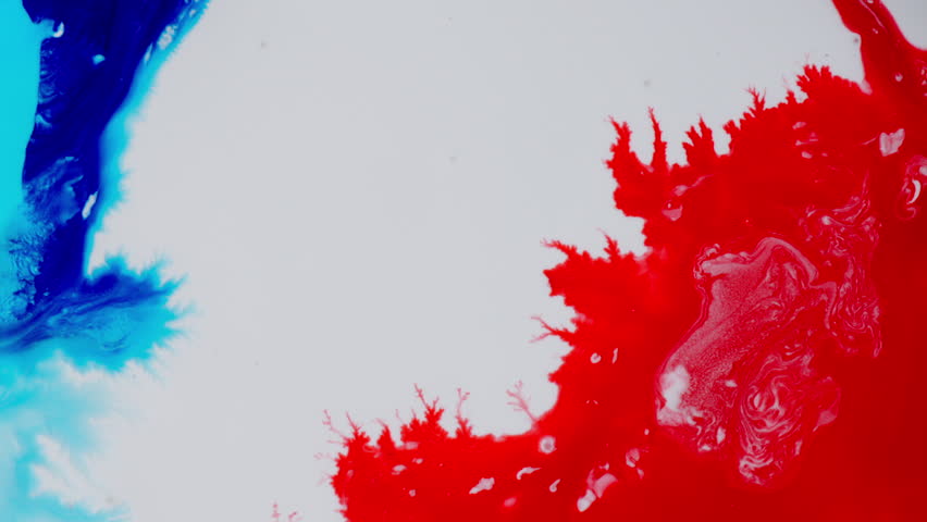 Vibrant macro of blue and red ink mixing, creating abstract patterns